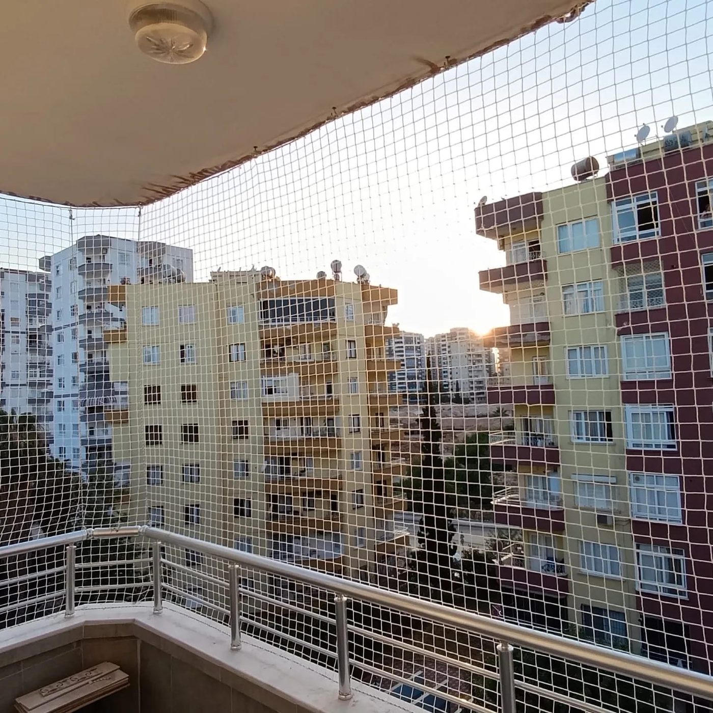 Balkona uygulanmış beyaz güvenlik filesi